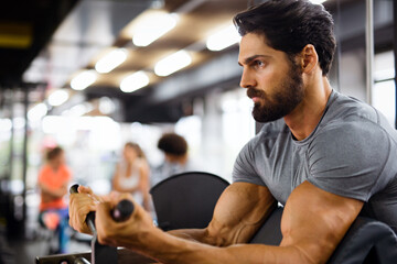 Muscular bodybuilder handsome man doing exercises in gym. Sport people workout concept