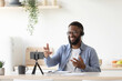 © Prostock-studio - Glad millennial african american man teacher with beard in glasses and headphones gestures with hands