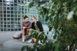© LIGHTFIELD STUDIOS - Positive couple of tourists sitting near backpacks and plants in hotel