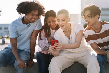 Wall Mural - Group of gen z friends sitting together using mobile phones to share content on social media