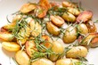 cooking fried potatoes in white pan