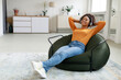 © Prostock-studio - Calm black woman having rest at home on bean bag