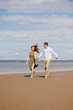 © MyJuly - a couple of a man and a woman are walking on the beach or running along the sand along the seashore. beautiful and young European man and woman on a romantic walk in nature, a couple in love, a happy