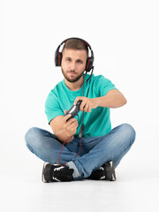 Wall Mural - Man playing videogames with a controller and a headphones in a white background