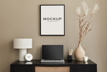 Stylish Composition Of Home Office Interior With Black Wooden Desk, Chair, Dried Flower In Vase, Laptop, Mock Up Poster Frame, Design Table Lamp, Clock And Elegant Office Accessories. Template.