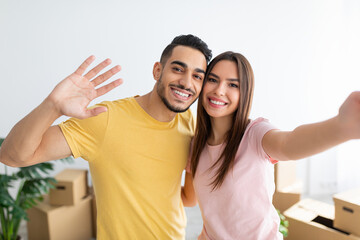 Poster - Beautiful Caucasian woman with her Arab husband taking selfie, moving to new house together