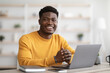 © Prostock-studio - Portrait of positive black guy working on laptop