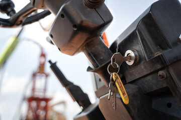 A forklift vehicle is ready to start the engine for operate at construction work site. Industrial working scene photo. Close-up and selective focus at engine's key.