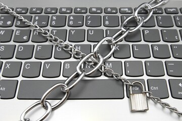 A computer keyboard with a chain and a padlock, cybersecurity concept