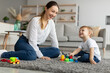 © Prostock-studio - Happy mom playing with toddler son stacking and sorting wooden toy, spending time with kid at home