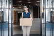 portrait of a female company employee standing outdoor with box of stuff. Leaving business. Female office worker lost her job.Job loss due to COVID-19 virus pandemic concept