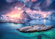 Aerial View Of Snowy Islands With Houses, Rorbu, Blue Sea, Mountains, Bridge And Colorful Cloudy Sky At Sunset In Winter. Dramatic Landscape With Village, Rock, Road. Top View. Lofoten Islands, Norway