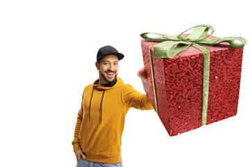 Wall Mural - Cheerful young man in a yellow sweatshirt holding a gift box