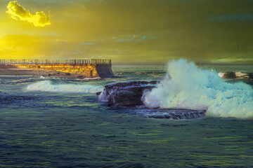 Wall Mural - 2022-01-05 THE CHIDRENS POOL AND WALKWAY IN LA JOLLA CALIFORNIA WITH WAVES CRASHING ON NEARBY ROCKS DURING DUSK WITH A CLOUDY SKY