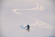 active freerider skilfully rides down white powdery snow of mountain slope