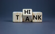 Think tank symbol. Businessman turns a wooden cube and changes the word tank to think. Beautiful grey table, grey background, copy space. Business and think tank concept.