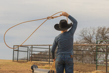 Young Boy Swinging A Rope At A Roping Dummy 