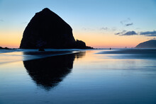 Cannon Beach Dusk Solitude. Evening Twilight At Haystack Rock In Cannon Beach, Oregon As The Surf Washes Up Onto The Beach. United States.

