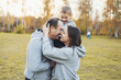 © Strelciuc - MIddle-aged parents with their little son standing in the park outdoors. Family day.