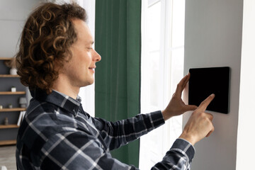 Poster - Man Using Tablet On Wall With Smart Home Application Indoors