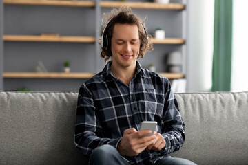 Poster - Millennial Man Enjoying Music Using Phone Wearing Headphones At Home