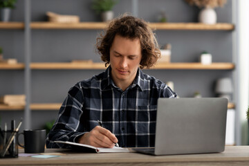 Poster - Serious Business Guy Working On Laptop Taking Notes In Office