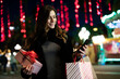 © Jelena - Beautiful woman holding shopping bags. Portrait of happy woman during Christmas shopping..