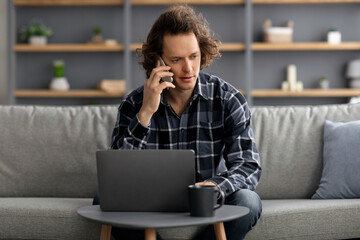 Poster - Serious Man Talking On Phone Sitting At Laptop At Home