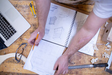 Carpenter Brainstorming And Sketching In Workshop