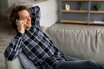 Poster - Contented Man Talking On Phone Lying On Sofa At Home