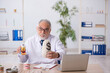 © Elnur - Old male doctor dentist in remuneration concept