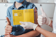 Doctor And Boy With Vaccination Certificate Showing Thumbs Up At Center