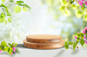 Leinwandbilder - Beautiful bright natural template for product presentation in the form of wooden pedestal or podium framed with fresh green foliage  and flowers on light background.