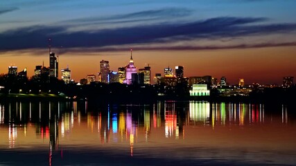 Wall Mural - Tranquil evening skyline of Warsaw, capital of Poland river view, city downtown with reflection in water.