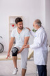 © Elnur - Young leg injured patient visiting old male doctor