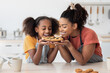 © Prostock-studio - Delighted black mother and teen daughter smelling homemade pie
