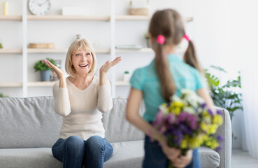 Wall Mural - Back view of girl greeting woman with flowers