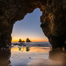 Sunrise At A Secret Beach And Cave On Portugal's Algarve Coast. Only Accessible At Low Tide Through A Tunnel