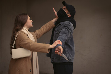 Canvas Print - Woman defending herself from attacker with knife near building