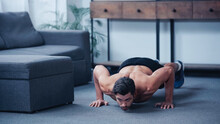 Surface Level View Of Young Sportsman Doing Press Ups On Floor At Home