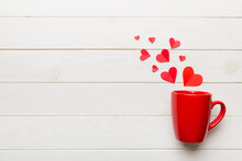 Red Cup On Colored Background, Splashes Of Red Little Hearts, Top View With Copy Space