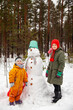 © DariaTrofimova - Two sisters making  snowman  in winter  forest