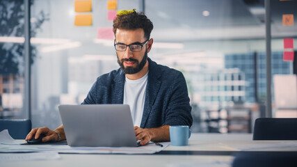 Poster - Modern Office: Portrait of Young Stylish Businessman Wearing Glasses Works on Laptop, Does Data Analysis, Website Design, Creative Developemnt. Digital Entrepreneur Works on e-Commerce Startup Project