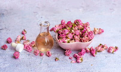 Rose  essential oil in glass bottle and pink rose flowers . Rose water 