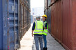 © NVB Stocker - Hispanic Man worker and woman Supervisor dock cargo checking and control loading Containers box at container yard port of import and export goods. Unity and teamwork concept