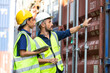 © NVB Stocker - Hispanic Man worker and woman Supervisor dock cargo checking and control loading Containers box at container yard port of import and export goods. Unity and teamwork concept