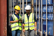 © NVB Stocker - Hispanic Man worker and woman Supervisor dock cargo checking and control loading Containers box at container yard port of import and export goods. Unity and teamwork concept