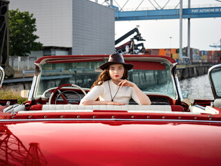 Wall Mural - 60-s oldtimer red Cadillac and a beautiful young girl