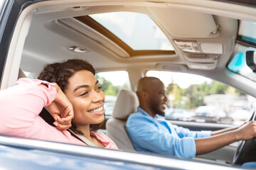 Wall Mural - Happy black couple enjoying drive on luxury car