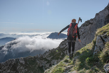 Wall Mural - chica en la montaña con una mochila y mar de nubes de fondo